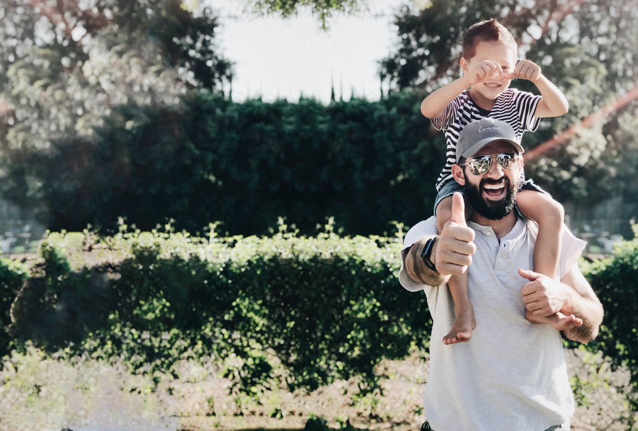 boy riding on fathers shoulders